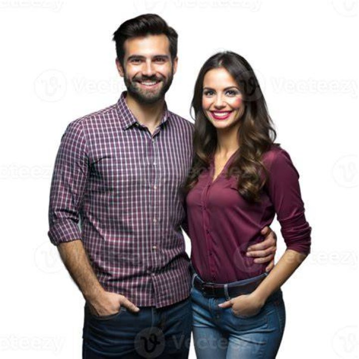 a man and woman standing in front of a christmas tree