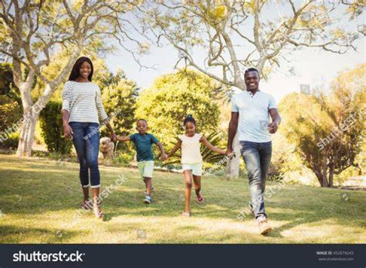the family is walking together down the street with one holding their
