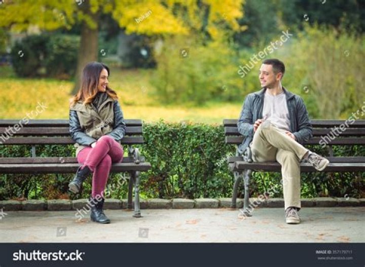 two young people sitting on a couch with one holding his arm around the